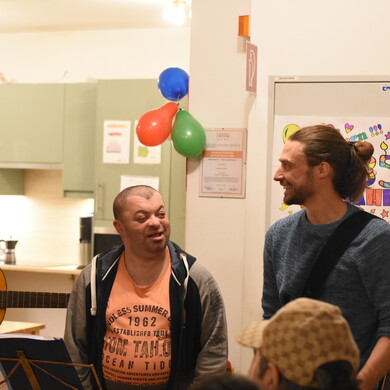 Jobs in der Behindertenbegleitung bei BALANCE Auf einer Feier von BALANCE unterhalten sich Menschen mit und ohne Behinderung.