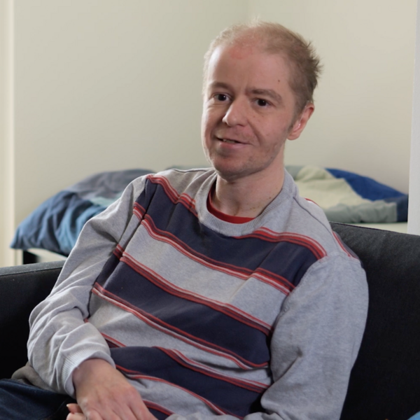 Bewohner Markus I BALANCE Ein Bewohner des Wohnverbunds Käthe Dorsch sitzt auf der Couch in seiner Wohnung.