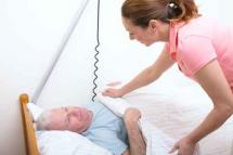 Pflegerin deckt Patienten zu